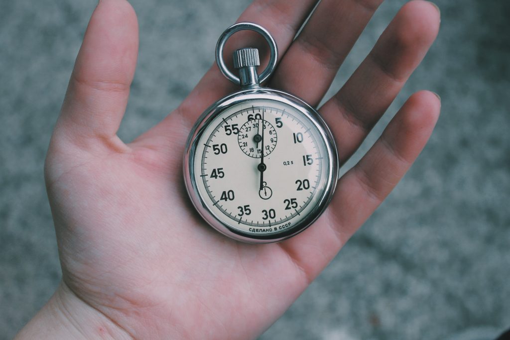 small pocket watch in a palm of a hand